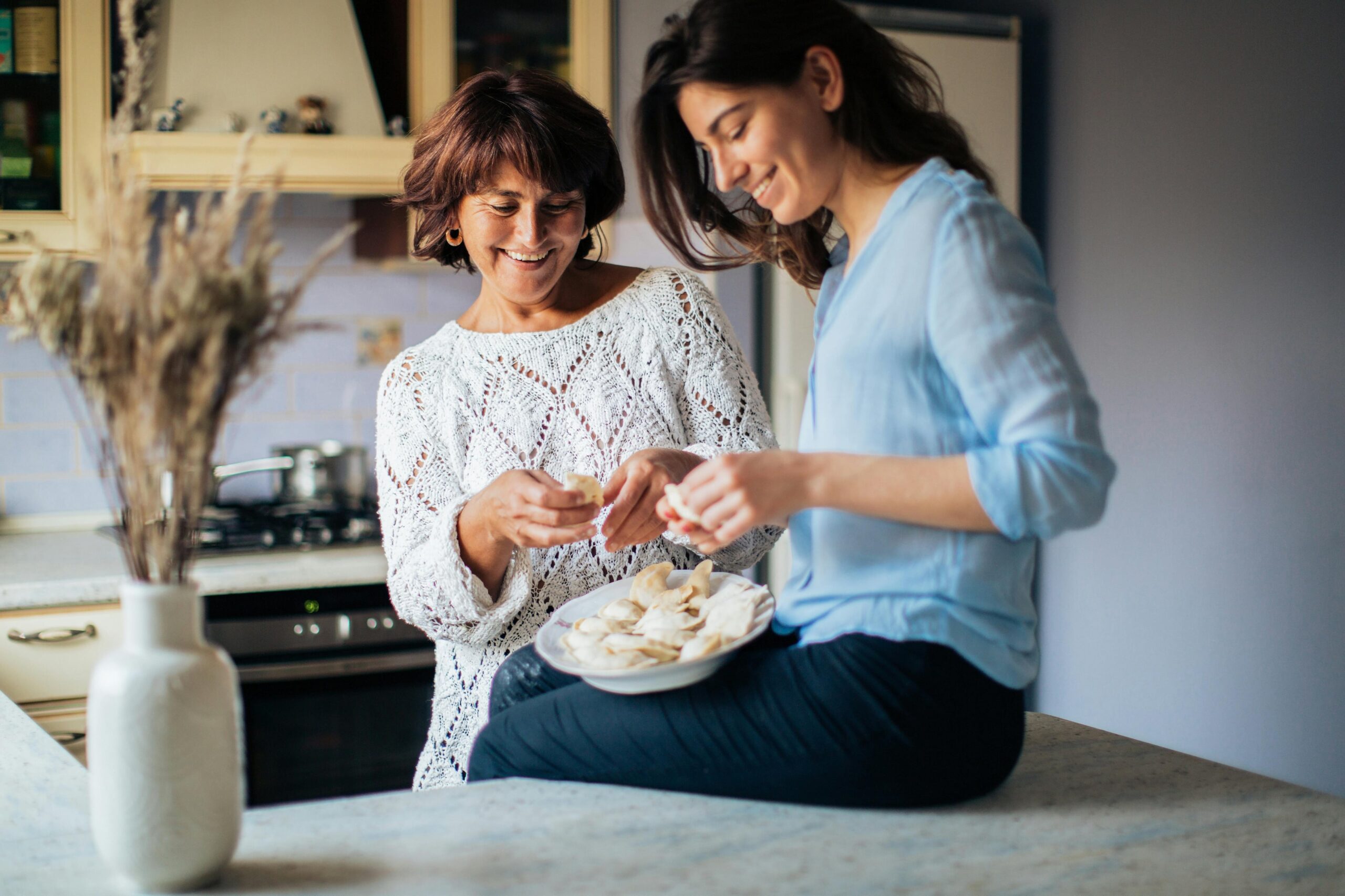 Two women in a kitchen having food